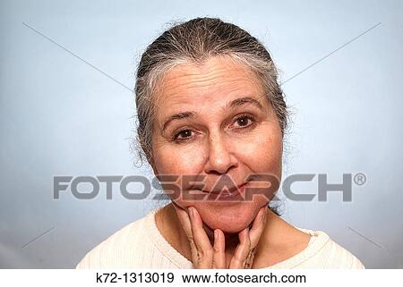 Stock Photograph - Older woman with a <b>half-hearted</b> grin. - k72-1313019