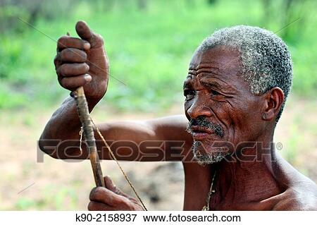 Picture - Old Jo/?hoansi San man working on a new bow, Namibia - k90-2158937