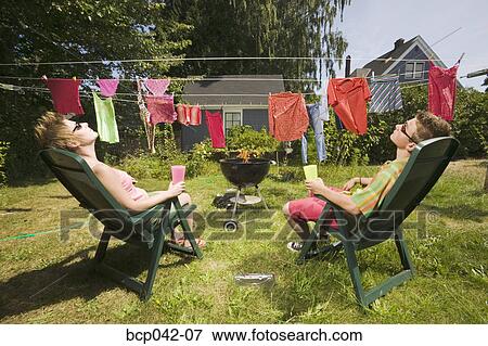 Picture  Couple sunbathing in back yard. Fotosearch  Search Stock 
