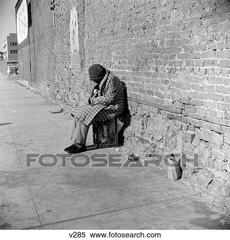 Stock Image Of Homeless Person Bundled In Winter Coat & Hat Sitting On 