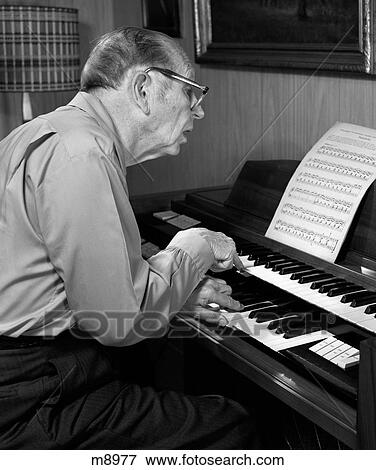 Picture of 1970S Elderly Man Wearing Glasses Leaning Forward To Read