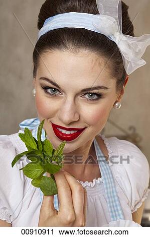 A retro-style girl holding fresh <b>mint leaves</b> - 00910911