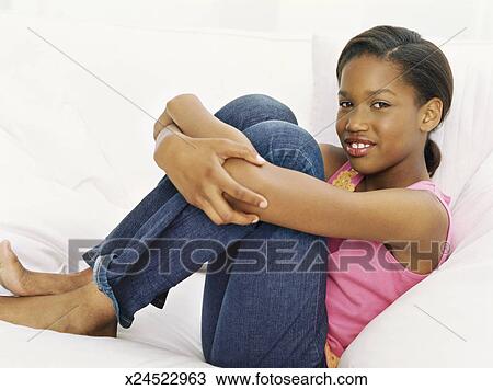 Stock Photo of portrait of a girl sitting on a couch and hugging her