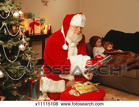 picture santa claus putting presents under christmas tree fotosearch search stock photos - Santa Claus With Presents picture santa claus putting presents under christmas tree fotosearch search stock photos - Santa Claus With Presents