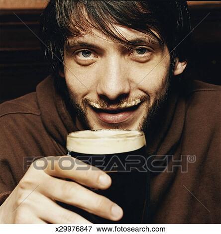Joven, el gozar, un, bebida, de, cerveza negra, en, un, bar - x29976847