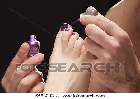 Image , gros plan, de, a, main homme, demande, vernis à ongles, sur, les, femme, ongles orteil