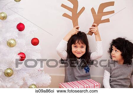 Dos niñas, preparación para navidad, juego, con, cartón, reno, cornamenta