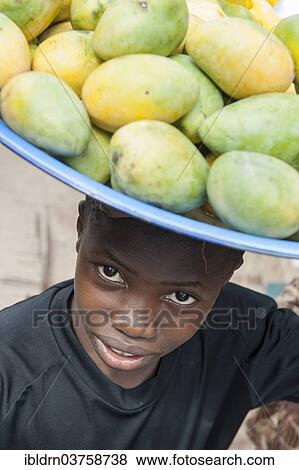 Picture - &quot;Young mango seller at a street market, Bo, Southern Province, - ibldrn03758738