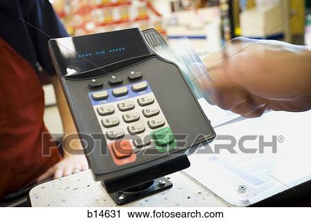 Stock Photography of Person swiping debit card at POS machine b14631