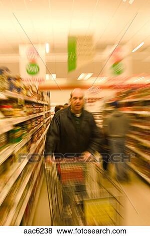 Picture - Middle-age balding man, wearing a leather jacket, shopping in a