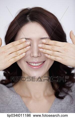 A woman in grey <b>plain shirt</b> covering her eyes - tip034t011186