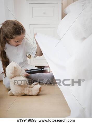 Picture - Young girl looking under bed. Fotosearch - Search Stock ...
