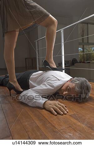 Stock Photograph of Woman standing on dead man's body u14144309