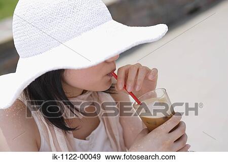 A woman wearing hat and drinking View Large Photo Image Stock Photo - A woman wearing hat and drinking. Fotosearch