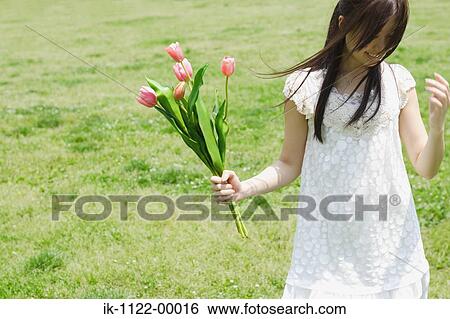 A young woman holding tulips View Large Photo Image Stock Photograph - A young woman holding tulips. Fotosearch