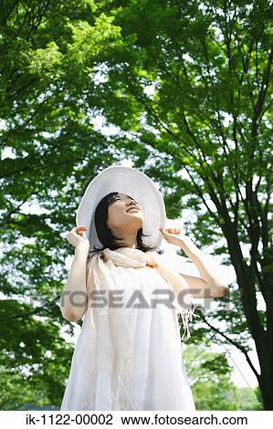 A young woman looking at green trees View Large Photo Image Stock Image - A young woman looking at green trees. Fotosearch