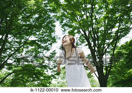 A young woman looking at green trees View Large Photo Image Stock Image - A young woman looking at green trees. Fotosearch