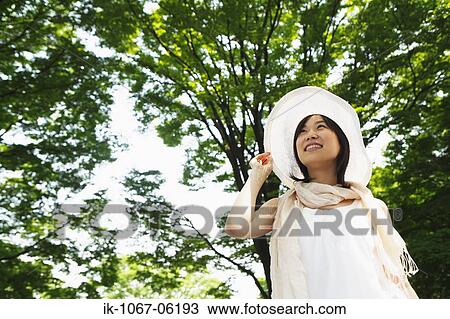 Stock Image - A young woman looking at sky. Fotosearch
