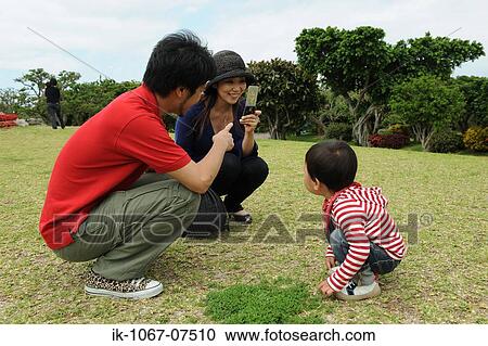 Asian couple taking photograph of his son in garden View Large Photo Image Stock Image - Asian couple taking photograph of his son in garden. Fotosearch
