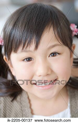 Asian girl smiling and looking at camera View Large Photo Image Stock Photo - Asian girl smiling and looking at camera. Fotosearch