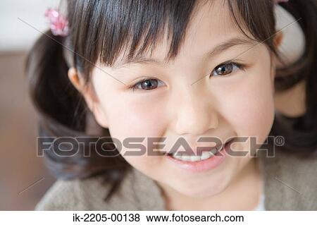 Asian girl smiling and looking at camera View Large Photo Image Stock Photo - Asian girl smiling and looking at camera. Fotosearch