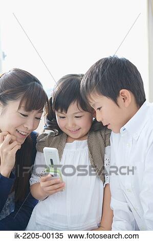 Asian mother and her children looking on cellphone View Large Photo Image Stock Photography - Asian mother and her children looking on cellphone. Fotosearch