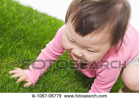 Stock Photo - Baby crawling in grass. Fotosearch