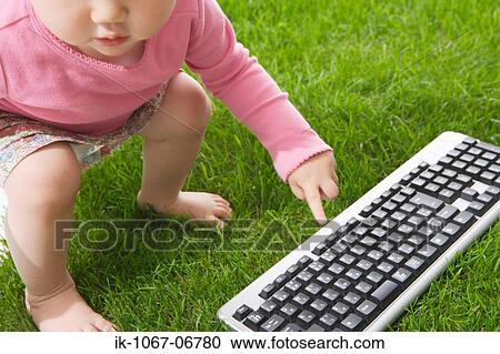 Stock Image - Baby pointing to keyboard. Fotosearch
