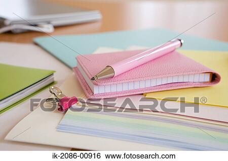 Stock Photograph - Binder Clip Holding Paper and Diary with Pen. Fotosearch