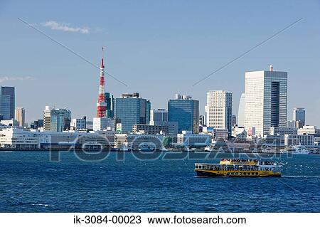Stock Image - Boat travelling in sea with buildings in background. Fotosearch