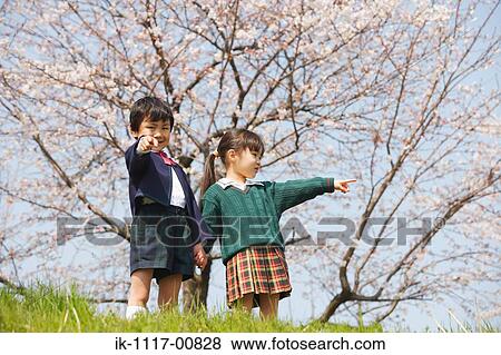 Stock Photo - Boy and girl standing in park holding hands. Fotosearch