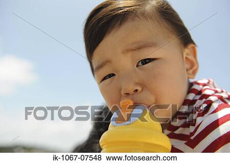 Stock Photo - Boy drinking from a plastic beaker. Fotosearch