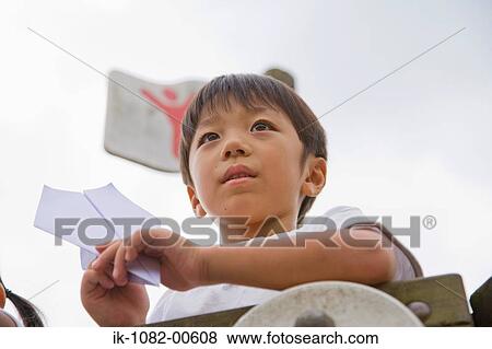 Stock Photo - Boy holding paper aeroplane. Fotosearch