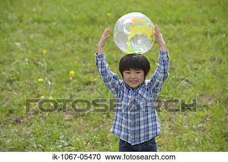 Boy playing with a ball in park View Large Photo Image Stock Image - Boy playing with a ball in park. Fotosearch