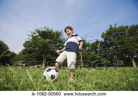 Boy playing with football in park View Large Photo Image Stock Image - Boy playing with football in park. Fotosearch
