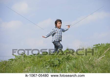 Boy running with paper airplane in park View Large Photo Image Stock Image - Boy running with paper airplane in park. Fotosearch