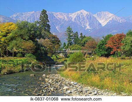 Bridge crossing river with scenic mountains in background View Large Photo Image Stock Photo - Bridge crossing river with scenic mountains in background. Fotosearch