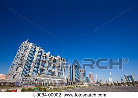 Stock Image - Buildings in shopping mall against blue sky. Fotosearch
