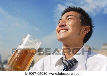Stock Image - Businessman Holding a Beer. Fotosearch
