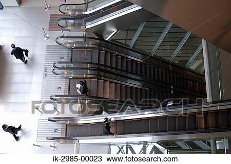 Stock Image - Businessman Using Escalator at Tokyo, Japan. Fotosearch