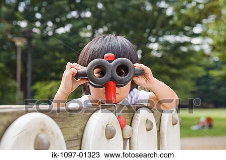 Stock Image - Child looking from binocular toy. Fotosearch