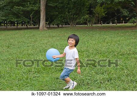 Child playing with a ballon in park View Large Photo Image Picture - Child playing with a ballon in park. Fotosearch