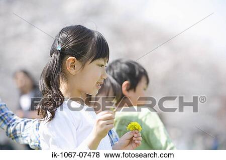 Stock Photo - Child standing in a row and holding flower. Fotosearch