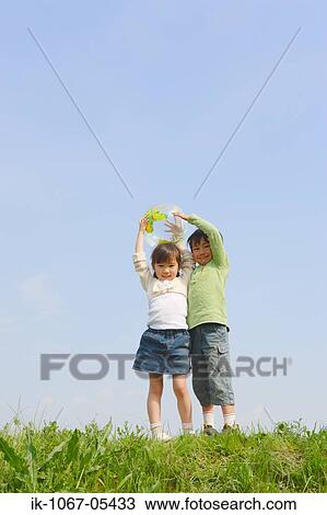 Children holding ball in park against blue sky View Large Photo Image Stock Image - Children holding ball in park against blue sky. Fotosearch