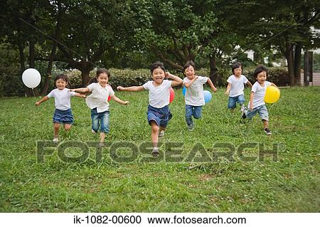 Children holding balloons and running in park together View Large Photo Image Stock Image - Children holding balloons and running in park together. Fotosearch