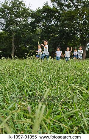 Children playing together in a park View Large Photo Image Stock Photography - Children playing together in a park. Fotosearch