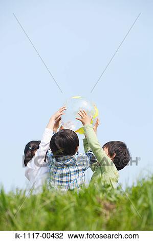 Stock Image - Children playing together with a ball. Fotosearch