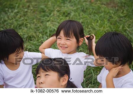 Stock Photograph - Children sitting in park together. Fotosearch