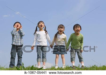 Stock Image - Children standing in a row and yelling together. Fotosearch