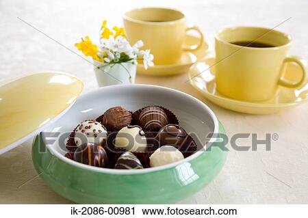 Stock Image - Chocolates Bowl and Coffee Cup on Table. Fotosearch